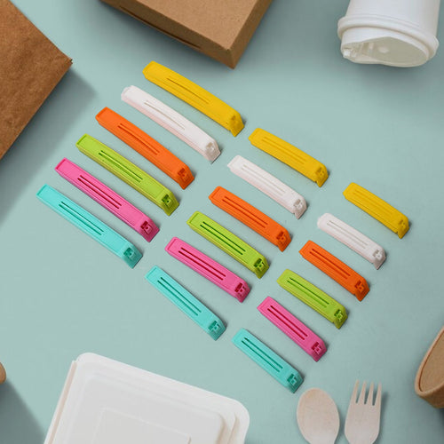 A hand sealing a snack bag with a blue airtight food clip.