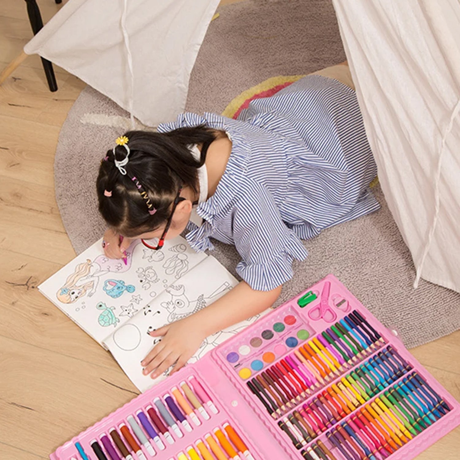 Young girl happily drawing with the comprehensive Craftily Kids Art Set.